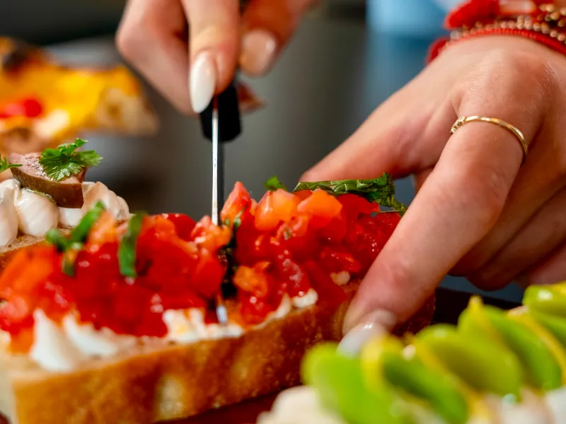 Genusstour: Bruschetta mit Tomaten wird für die Gäste aufgeschnitten.