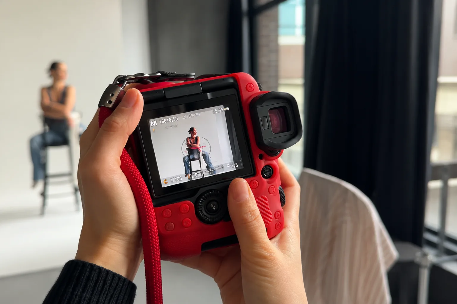 Rote Kamera im dibe Studio – auf dem Display posiert ein Model auf einem Barhocker.